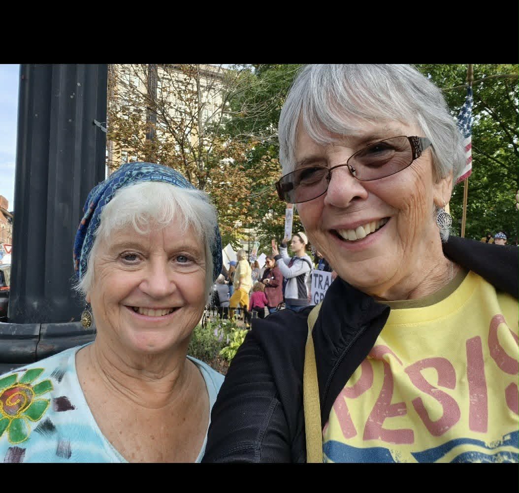 Two Indivisible Binghamton members at a rally, one wearing a 'Resist' shirt